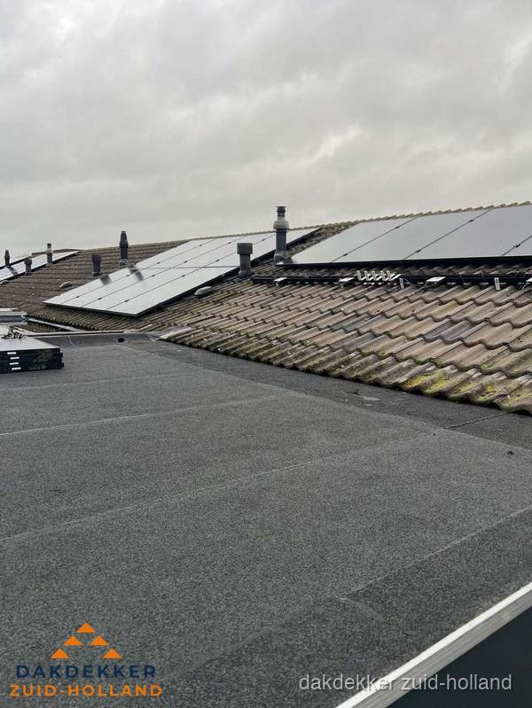 Bitumen dakbedekking op plat dak met aansluitend pannendak en zonnepanelen in Zuid-Holland