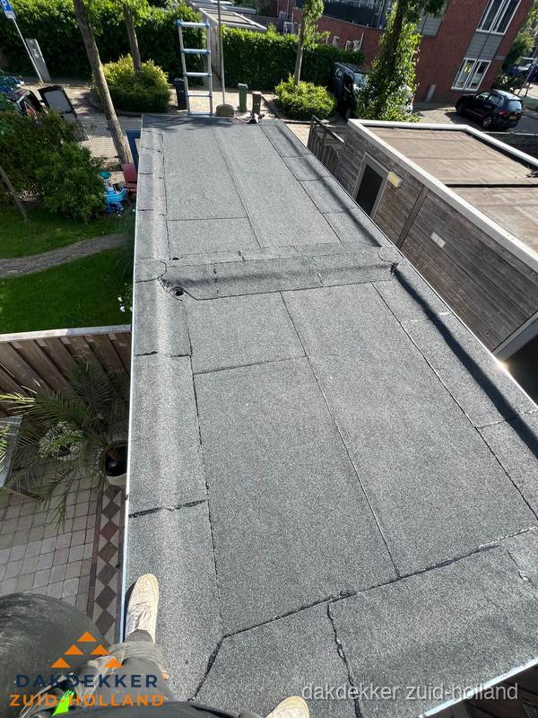 Bitumen plat dak rijtjeswoning vanuit dakdekker perspectief in Zuid-Holland