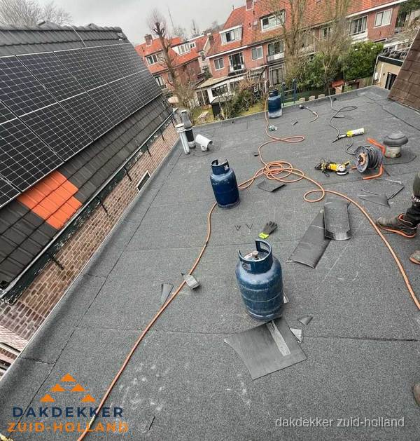 Daklekkage repareren met brandgereedschap op plat dak in Zuid-Holland