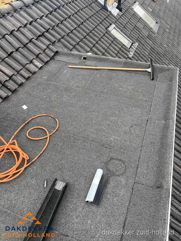 Plat dak reparatie met gereedschap en loodstroken in Zuid-Holland