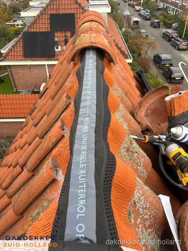 Dakdekker vervangt nokvorst met ruiterrol op pannendak in Zuid-Holland