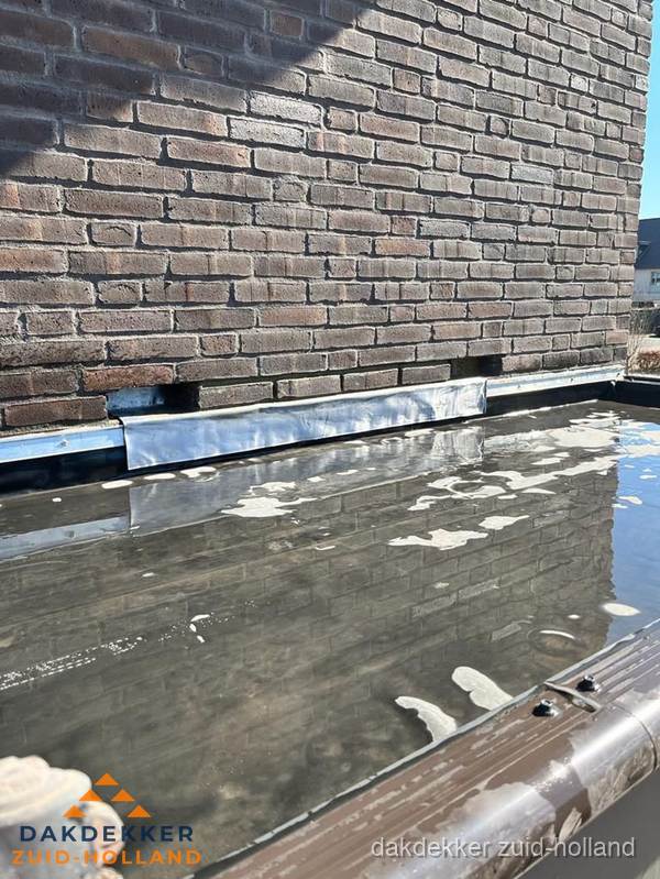 Stilstaand water op plat dak door slechte afwatering in Zuid-Holland Stilstaand water op plat dak door slechte afwatering in Zuid-Holland