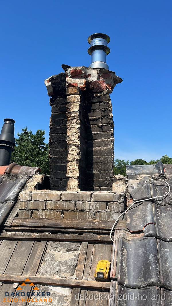 Beschadigde schoorsteen met nieuwe rookgasafvoer op oud dak in Zuid-Holland Beschadigde schoorsteen met nieuwe rookgasafvoer op oud dak in Zuid-Holland