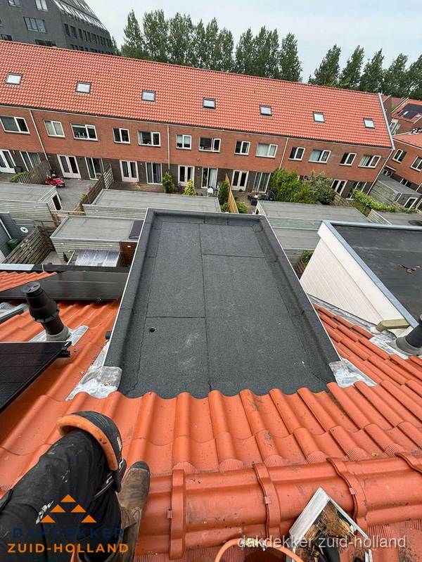 Bitumen dak reparatie op plat dak tussen dakpannen in Zuid-Holland