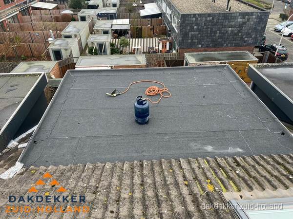 Plat dak met bitumen dakbedekking en brander in Zuid-Holland