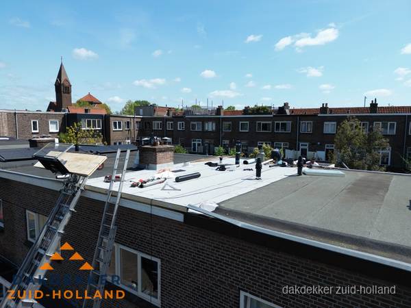 Dakdekkers aan het werk op plat dak in Zuid-Holland