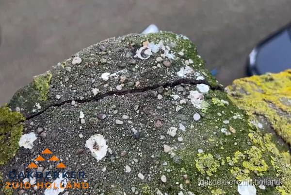 Beschadigde en verweerde nokvorst met scheuren en mos in Zuid-Holland